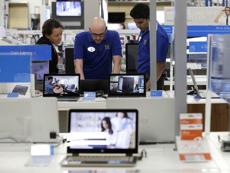 Employees assist a customer with a computer at a Best Buy store in Cary, N.C., in this May photo. Consumer spending rose just 0.1 percent in May after climbing 0.4 percent in both March and April.