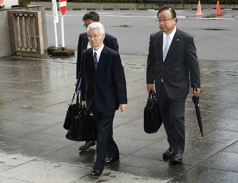 Tsunehisa Katsumata (center), former chairman of Tokyo Electric Power Co., accompanied by his lawyers, arrives Friday at Tokyo District Court for the start of a trial on charges of negligence in the 2011 Fukushima nuclear disaster.