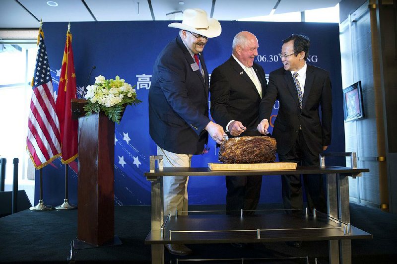 Craig Uden  (from  left), president of  the National Cattlemen’s Beef Association; U.S. Secretary of  Agriculture Sonny Perdue; and Luan Richeng, vice president of China’s state-owned China National Cereals, Oils and Foodstuffs Corp., slice into a cut of prime rib at an event Friday in Beijing to mark  the re-introduction of U.S. beef exports to China.