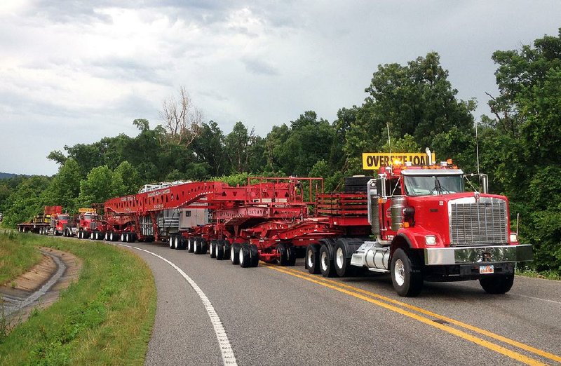 A million-pound “superload” is hauled up a mountain north of Cincinnati in Washington County on Friday afternoon on its way to its new location 10 miles southeast of Siloam Springs. It took two days to move a 454,000-pound autotransformer 56 miles from a substation in Tontitown to one near Siloam Springs.