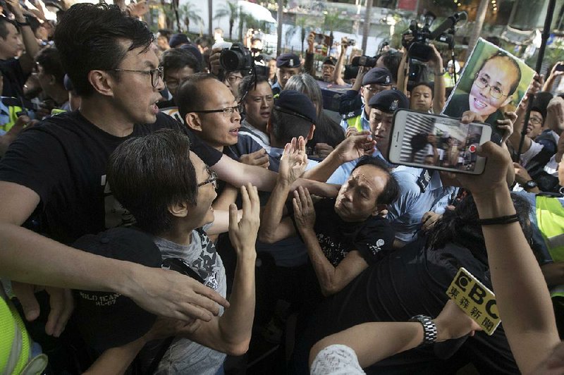 Pro-democracy protesters clash with pro-Chinese counterprotesters Saturday in Hong Kong during a march to demand greater openness and to oppose China’s creeping infl uence in the city.