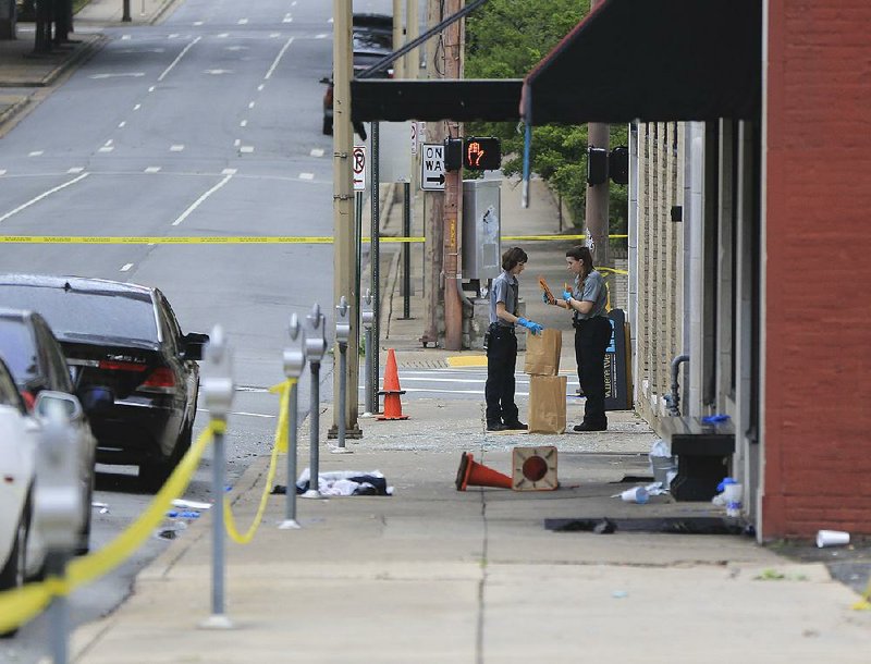 Little Rock Police Department crime scene personnel collect evidence Saturday morning after the shooting at Power Ultra Lounge at 220 W. Sixth St.