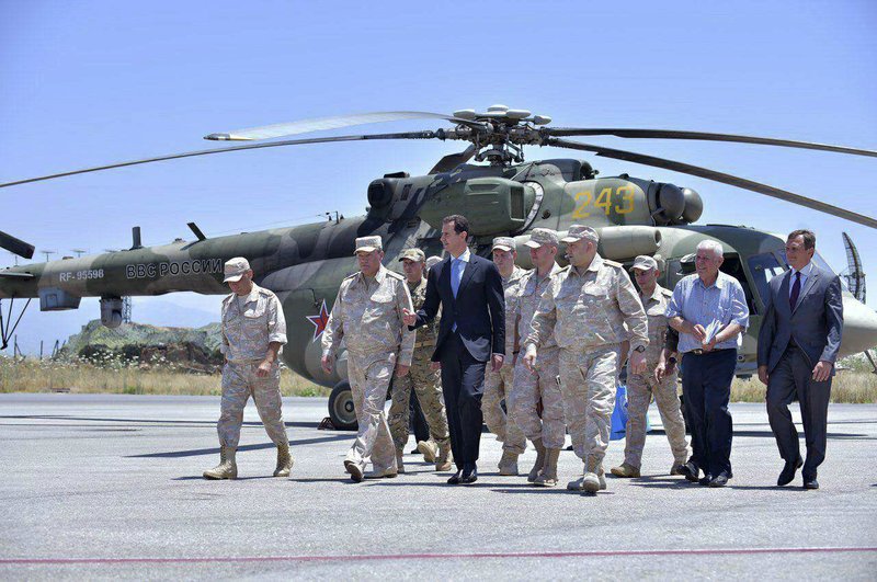 In this June 27, 2017 file photo and released on the official Facebook page of the Syrian Presidency, Syrian President Bashar Assad inspects the Russian Hmeimim air base in the province of Latakia, Syria. 