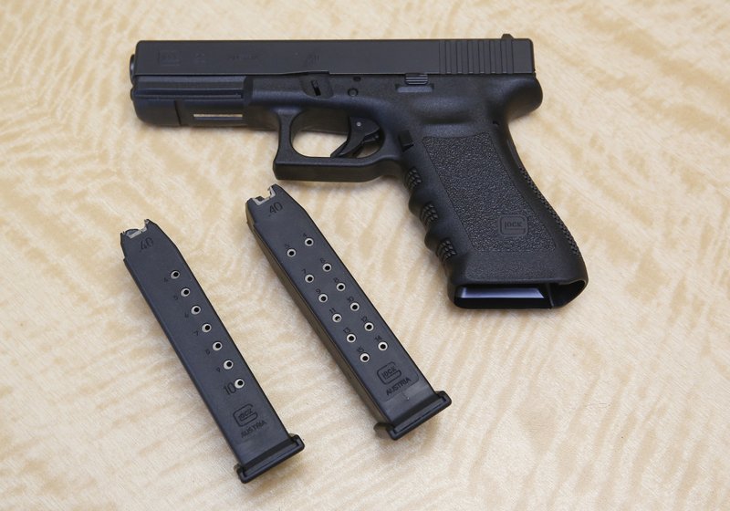 In this Tuesday, June 27, 2017 photo, a semi-automatic hand gun is displayed with a 10 shot magazine, left, and a 15 shot magazine, right, at a gun store in Elk Grove, Calif. 