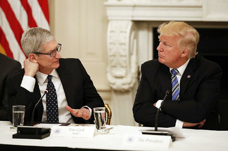 Apple CEO Tim Cook speaks with President Donald Trump at an American Technology Council session in the State Dinning Room of the White House in June.
