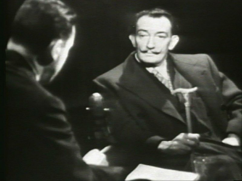 Interviewed in 1958 by Mike Wallace (left), Salvador Dali said, illeistically, “Dali is immortal and will not die.”
