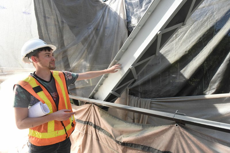 Dylan Buckley with Great River Engineering shows Wednesday the second coat of paint applied to the War Eagle Bridge. The final coat will be gloss black, the original color of the bridge.