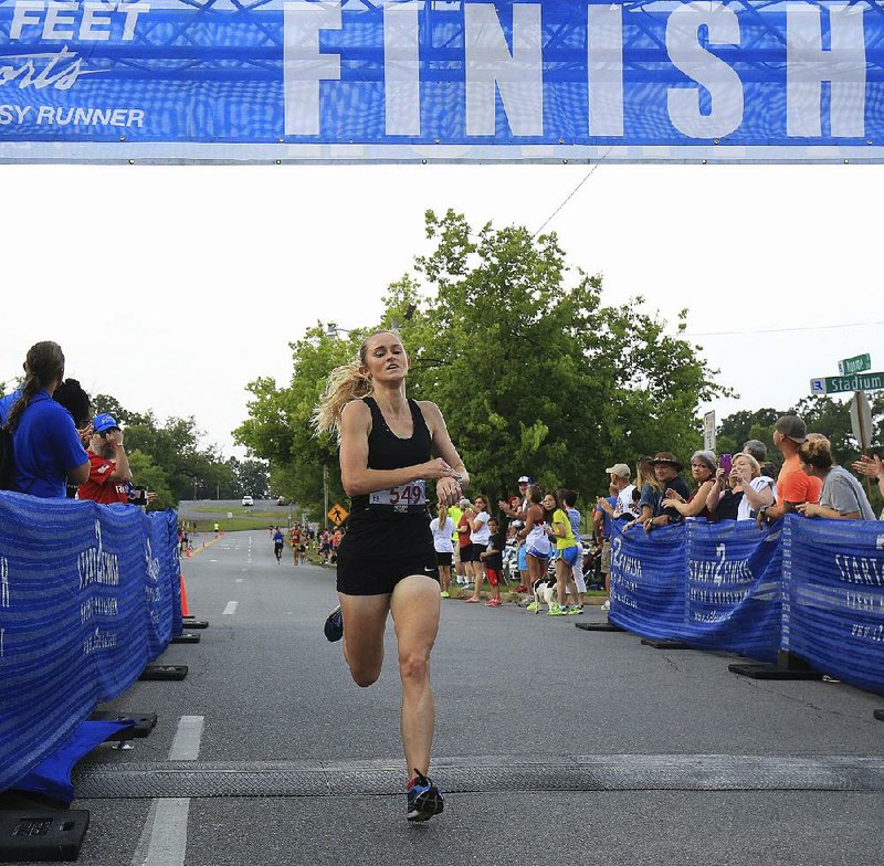 Cheryl Nolan of Jonesboro crosses the finish line on North Monroe Street near War Memorial Stadium in Little Rock to win the women’s division of the Firecracker Fast 5K on Tuesday with a time of 16 minutes, 58.69 seconds. 