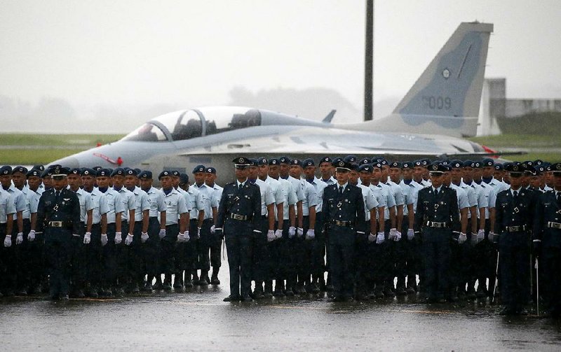 Philippine air force personnel stand at attention in heavy rain Tuesday as President Rodrigo Duterte speaks during a ceremony marking the 70th anniversary of the force at Clark Freeport Zone north of Manila. Meanwhile, the Philippine Supreme Court upheld Duterte’s declaration of martial law in the south of the country to combat militants. 