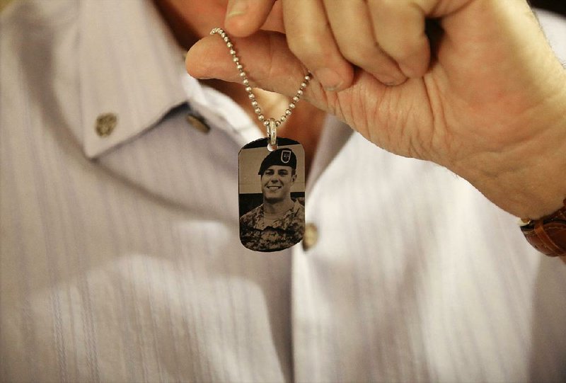 Brian McEnroe, father of U.S. Green Beret Kevin McEnroe, displays a memorial dog tag in June that depicts his son, who was killed by gunfire in Amman, Jordan, last year.