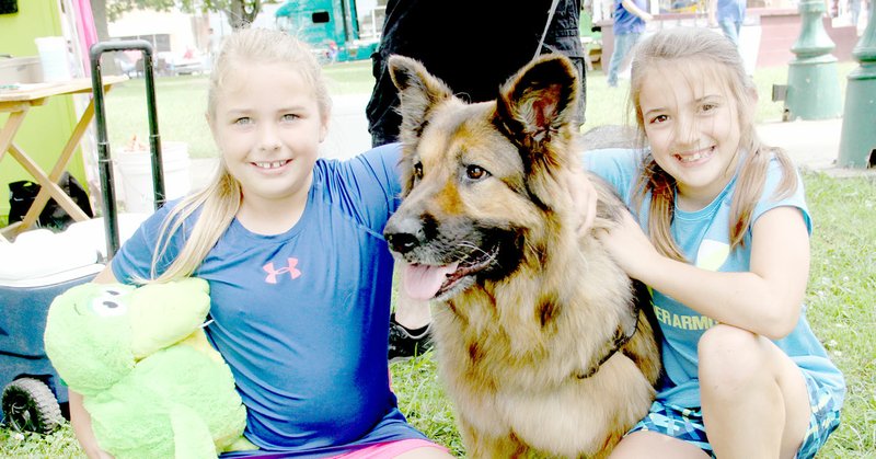 LYNN KUTTER ENTERPRISE-LEADER Jacey Provence, left, and Layne Birkes, both of Lincoln, pose with Karli, a long-haired German Shepherd owned by Marilyn Miles with Lincoln Pound Pals. Lincoln City Council recently approved a new contract with the Pals to help pay more of the costs to take dogs to the Washington County Animal Shelter. Karli was helping to raise money for the non-profit organization during the Chicken Rod Nationals Car Show in Lincoln on June 24.