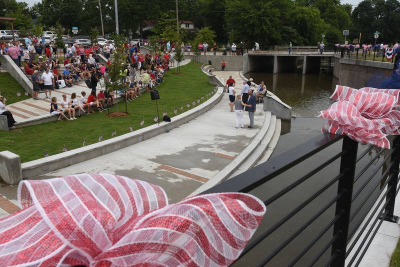 NWA Democrat-Gazette/FLIP PUTTHOFF Dedication of the new Walter Turnbow Park in downtown Springdale draws a crowd Tuesday. Mill Creek flows through the park named for Walter Turnbow, who has served Springdale for years in a long list of city and philanthropic roles.