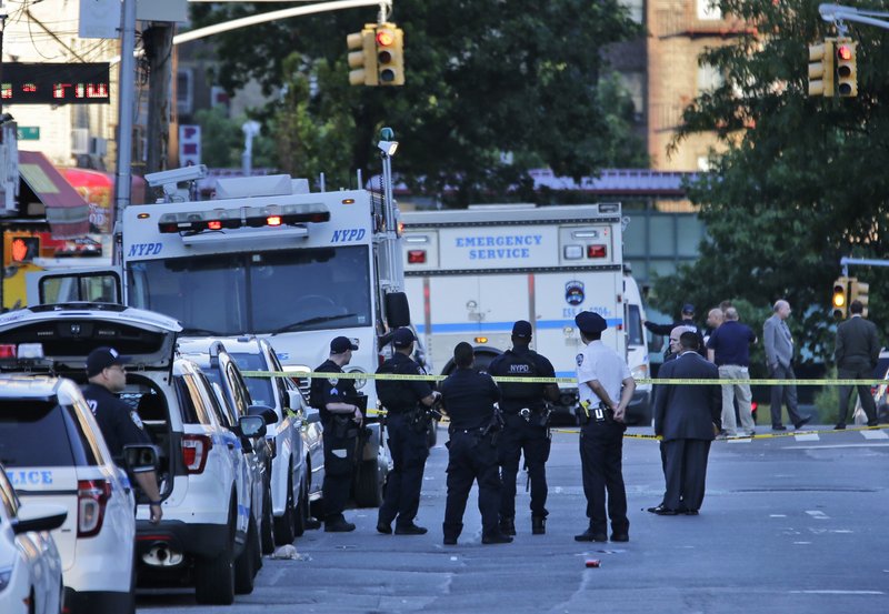Emergency personnel stand near the scene where a police officer was fatally shot while sitting in a marked vehicle in the Bronx section of New York, Wednesday, July 5, 2017. Police said Officer Miosotis Familia died at a hospital early Wednesday. (AP Photo/Seth Wenig)
