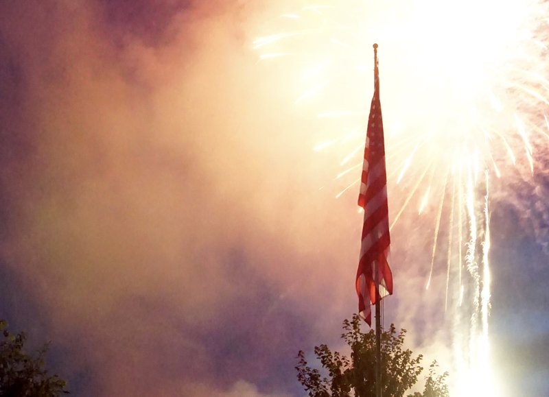 Fireworks lit up the sky behind Old Glory, awing the thousands in attendance for the annual Freedom Festival in Gentry's city park on Tuesday, July 4th. 