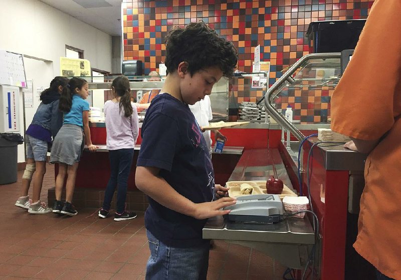 Third-grader Lucas Jameson keys in his student ID number to deduct a meal payment in May at the
Gonzales Community School in Santa Fe, N.M.