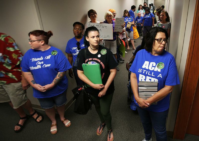 Protesters gather Thursday in the hallway outside Sen. Tom Cotton’s Little Rock office near the state Capitol for a sit-in urging Cotton to oppose the U.S. Senate’s proposed Republican health care plan. Similar demonstrations were held in Jonesboro and Springdale as part of a nationwide effort among a coalition of activists. 