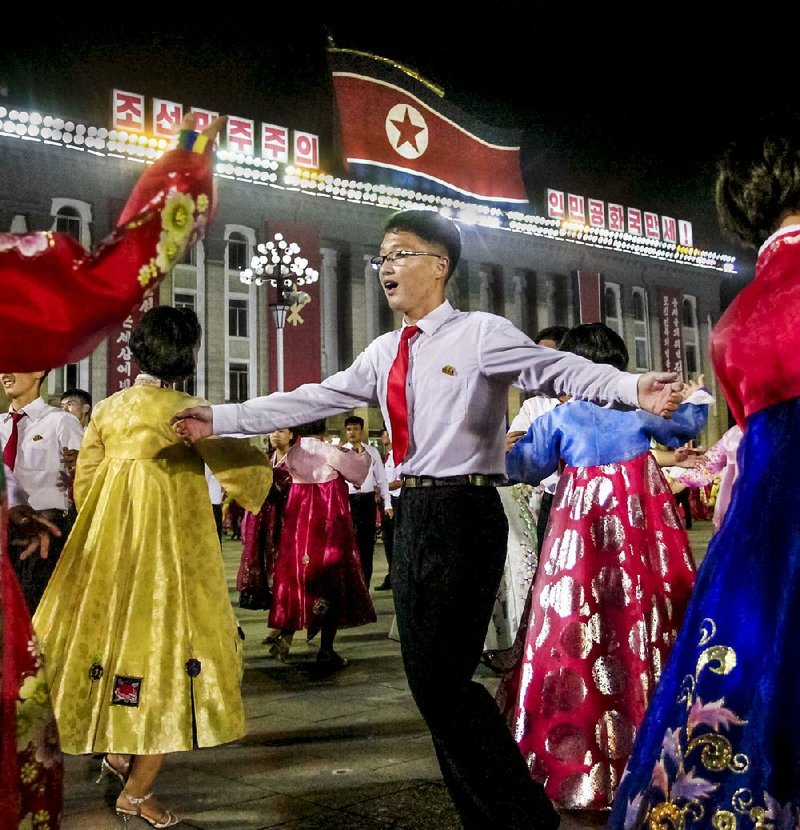 People dance Thursday in Kim Il Sung Square in Pyongyang to celebrate the test launch of North Korea’s first intercontinental ballistic missile, which took place earlier this week. 