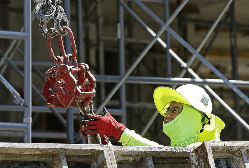 A construction worker builds a condominium complex in Coral Gables, Fla., earlier this week. The new Labor Department report said construction companies added 16,000 jobs in June. 