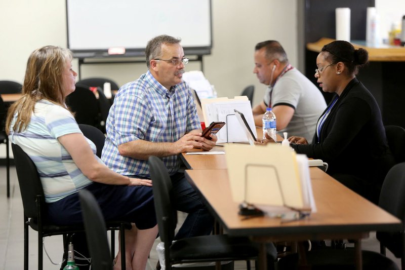 Aslin Davila (from right), applicant service program specialist, assists Darrell and Shelley Barron, of Washington County, Friday at the Federal Emergency Management Agency Recovery Center located in the Fayetteville Executive Airport Terminal Building at Drake Field. The center is designed to provide face-to-face recovery assistance to residents with needs after flood damage earlier this year.