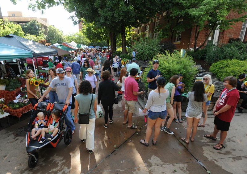 Residents walk Saturday while enjoying the Fayetteville Farmers’ Market on the city’s downtown square. Between 2010 and July 2016, Benton and Washington counties saw an increase in white residents which offset a reduction in the number of white residents in the state’s 73 other counties.