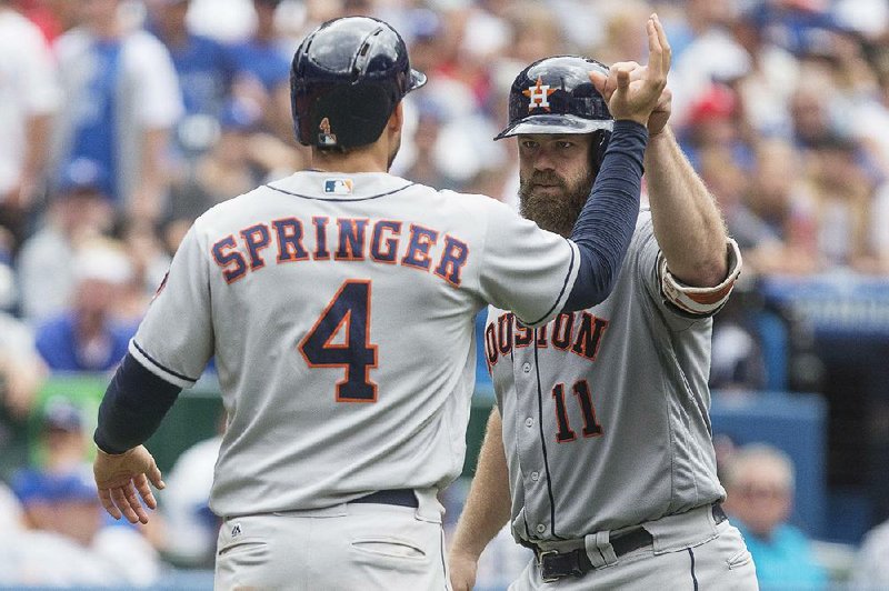 Houston catcher Evan Gattis (right) is congratulated by right fielder George Springer after Gattis’ three-run home run in the sixth inning of Sunday’s 19-1 blowout of Toronto.