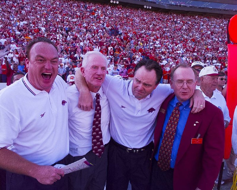 Arkansas defensive coordinator Keith Burns (from left), Athletic Director Frank Broyles, Coach Houston Nutt and Chancellor John White embrace after the Razorbacks — a year after losing to Tennessee 28-24 in Knoxville, Tenn. — held on to beat the Volunteers on Nov. 13, 1999, by the same score at Razorback Stadium in Fayetteville.