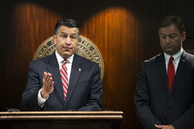 Nevada Gov. Brian Sandoval (left) and U.S. Sen. Dean Heller, R-Nev., hold a news conference last month in Las Vegas to announce the senator’s opposition to the GOP health care bill.