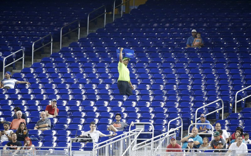 In this Tuesday, June 27, 2017, photo, a vendor walks through a section of mostly empty seats during the first inning of a baseball game between the Miami Marlins and the New York Mets at Marlins Park stadium in Miami. As the All-Star Game comes to Florida for the first time, the Marlins and Tampa Bay Rays continue their perennial struggles with attendance, raising the question: Does major league baseball belong in the state? 