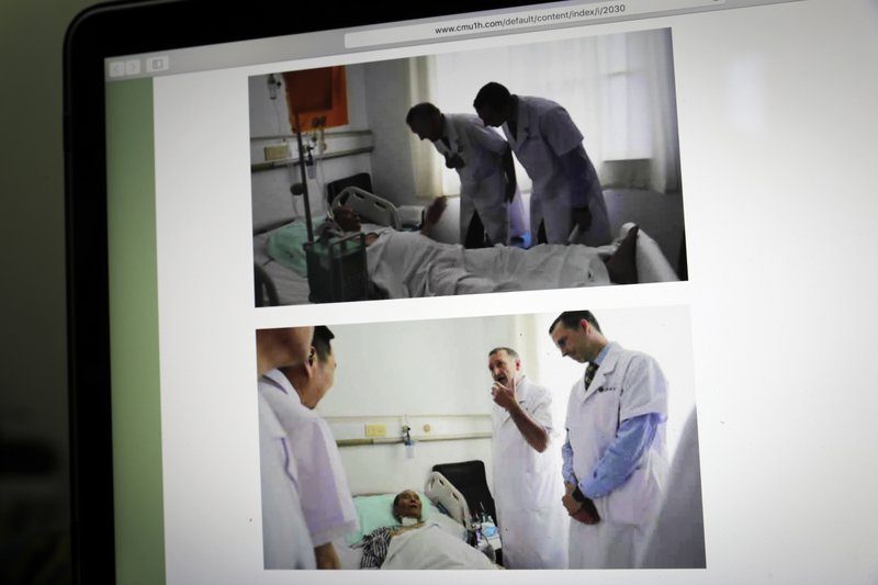 This image displayed on a screen in Beijing, Sunday, July 9, 2017, shows photos in the official website of the First Hospital of China Medical University in Shenyang, northern China, showing German Dr. Markus W. Buchler, left in top photo, and second right in bottom photo, of Heidelberg University, and American Dr. Joseph Herman, right in both top and bottom photos, of the MD &#xad;Anderson Cancer Center at the University of Texas, meeting with China's Nobel Peace Prize laureate Liu Xiaobo at the hospital. The two foreign specialists who visited Liu on Saturday said Sunday that the cancer-stricken Liu is still able to travel abroad for treatment, apparently contradicting statements by Chinese experts who say a medical evacuation would be unsafe. (AP Photo/Andy Wong)