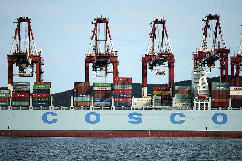 Containers are loaded onto a Cosco Shipping Holdings Co. container ship at a port in Qingdao in eastern China’s Shandong Province in this file photo. Cosco has bid $6.3 billion to buy competing shipping company Orient Overseas International Ltd.