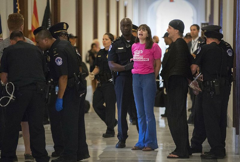 Activists protesting against the Republican health care bill outside Senate offices are taken into custody by U.S. Capitol Police on Monday on Capitol Hill.