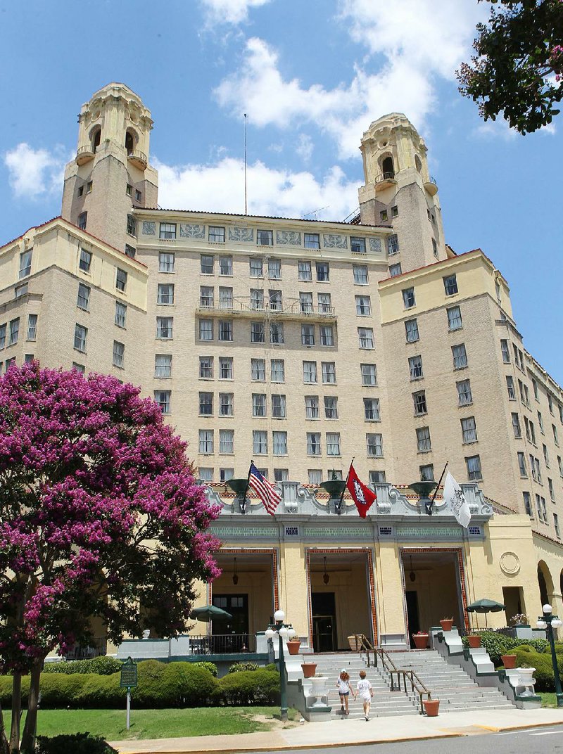 Pedestrians walk up the stairs at the Arlington Resort Hotel and Spa in Hot Springs on Monday. Sky Capital Group LP of Little Rock is buying the Arlington from Southwest Hotels Inc., owners and operators of the hotel since 1954.