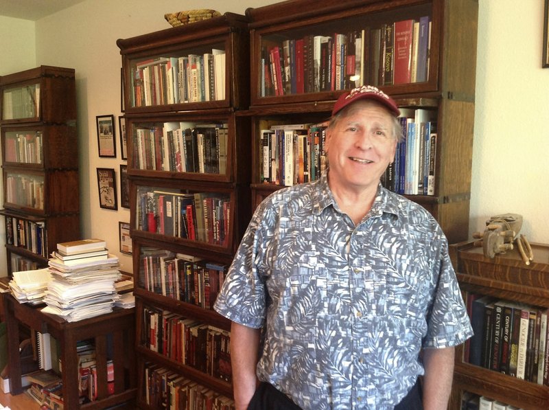 Sam Totten, a genocide expert and former University of Arkansas professor, stands Thursday in his home office in Springdale. Totten returned last month from a trip to east Africa to bring food to civilians in the Nuba Mountains of Sudan, one of several such trips he&#8217;s made in recent years.