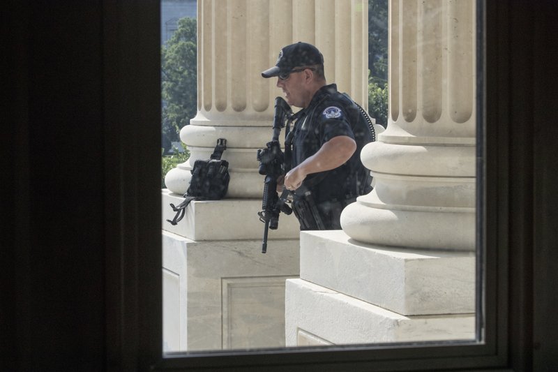 In this June 14, 2017 file photo, a Capitol Hill Police officer stands his post at the entrance to the House of Representatives on Capitol Hill in Washington. 