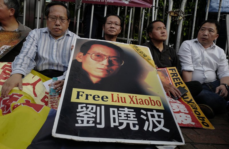 Protesters display portrait of jailed Chinese Nobel Peace laureate Liu Xiaobo during a demonstration outside the Chinese liaison office in Hong Kong, Monday, July 10, 2017.