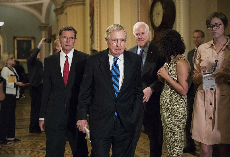 Senate Majority Leader Mitch McConnell (center) leaves a closed strategy session Tuesday on Capitol Hill with Sen. John Barrasso (left) of Wyoming and Senate Majority Whip John Cornyn of Texas.