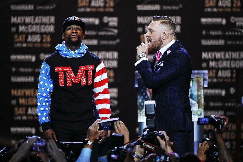 Floyd Mayweather Jr., left, and Conor McGregor pause for photos during a news conference at Staples Center Tuesday, July 11, 2017, in Los Angeles. The two will fight in a boxing match in Las Vegas on Aug. 26. 
