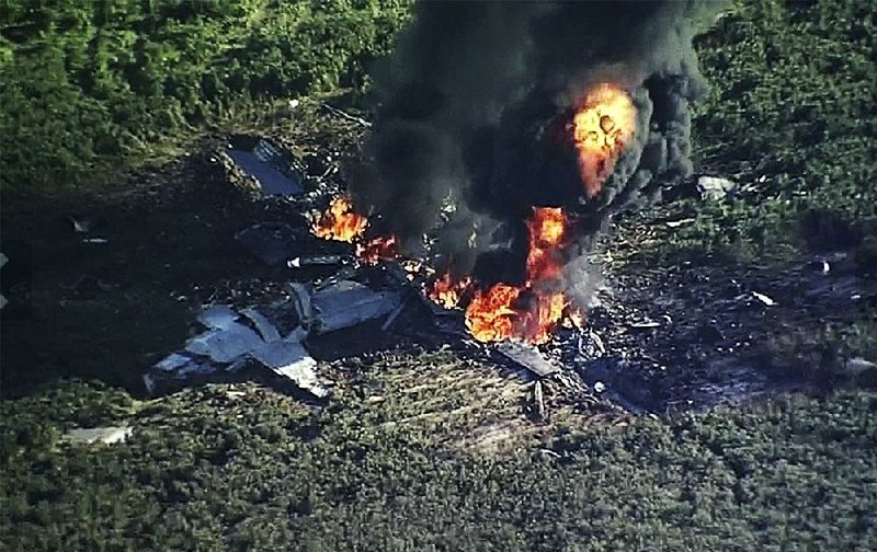 Smoke and flames rise from a military plane that crashed Monday in a farm field in Itta Bena, Miss. 