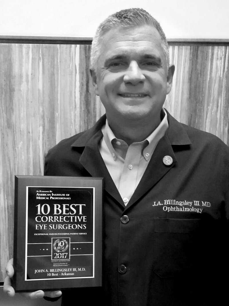 Submitted Photo Dr. John Billingsley, III, holds a plaque he was awarded for his patient care as a corrective eye surgeon.