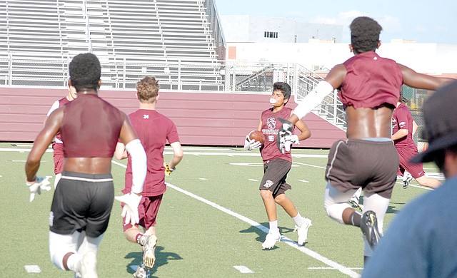 Graham Thomas/Herald-Leader Siloam Springs players celebrate after Angel Noyola makes an interception during 7-on-7 action on Monday night at Panther Stadium.