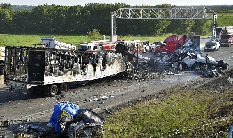 Investigators survey the scene of a multi-vehicle accident that claimed multiple lives Tuesday, July 11, 2017, on westbound Interstate 70 just west of Bonner Springs, Kan.