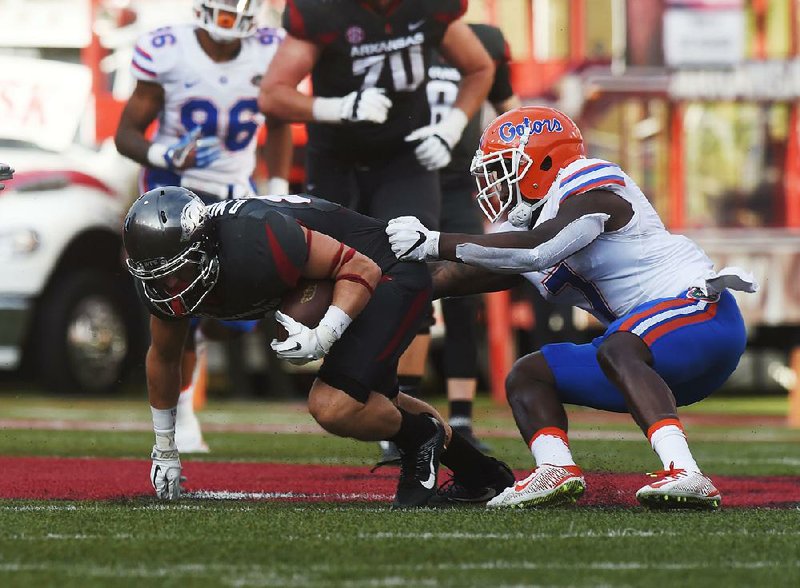 Former Arkansas wide receiver Drew Morgan (left) is taken down by Florida defensive back Duke Dawson during the Razorbacks’ 31-10 victory on Nov. 5 at Reynolds Razorback Stadium in Fayetteville. Dawson is one of six starters returning on defense for the Gators, who went 9-4 last season and are looking to win the SEC East for the third year in a row. 