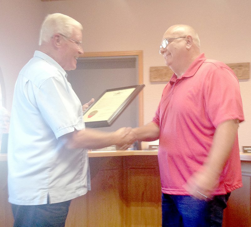 Sally Carroll/McDonald County Press State Rep. Bill Lant, left, presents Pineville Mayor and County Emergency Management Agency Director Gregg Sweeten with a resolution honoring him for his dedication to community.