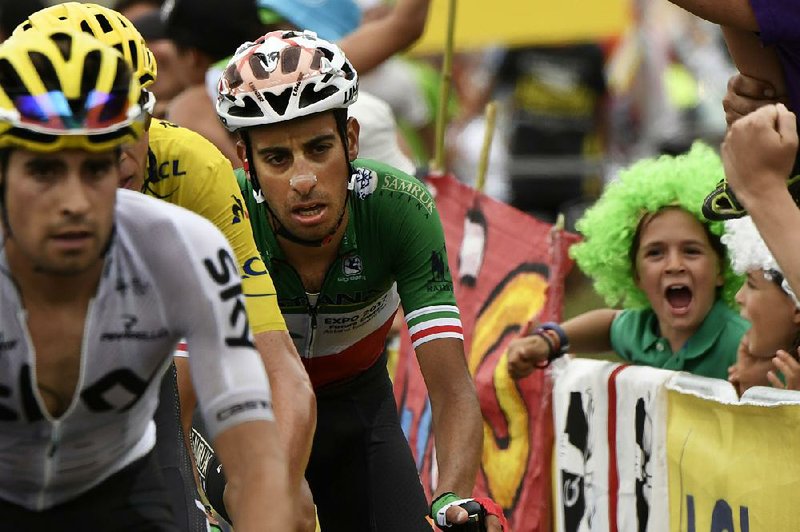Italy's Fabio Aru, in green, white and red jersey, who took over the overall leader's yellow jersey from Britain's Chris Froome, left, climbs during the twelfth stage of the Tour de France cycling race over 214.5 kilometers (133.3 miles) with start in Pau and finish in Peyragudes, France, Thursday, July 13, 2017.