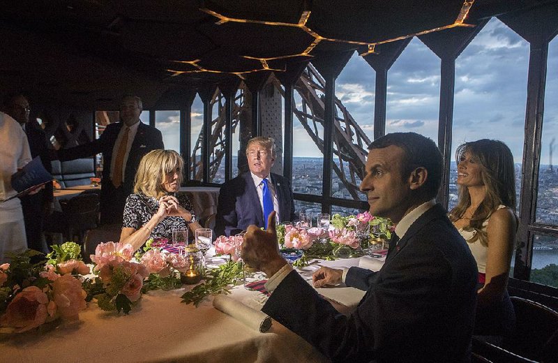 Brigitte Macron (clockwise from left), President Donald Trump, Melania Trump and French President Emmanuel Macron dine Thursday at the opulent Jules Verne restaurant in the Eiffel Tower.