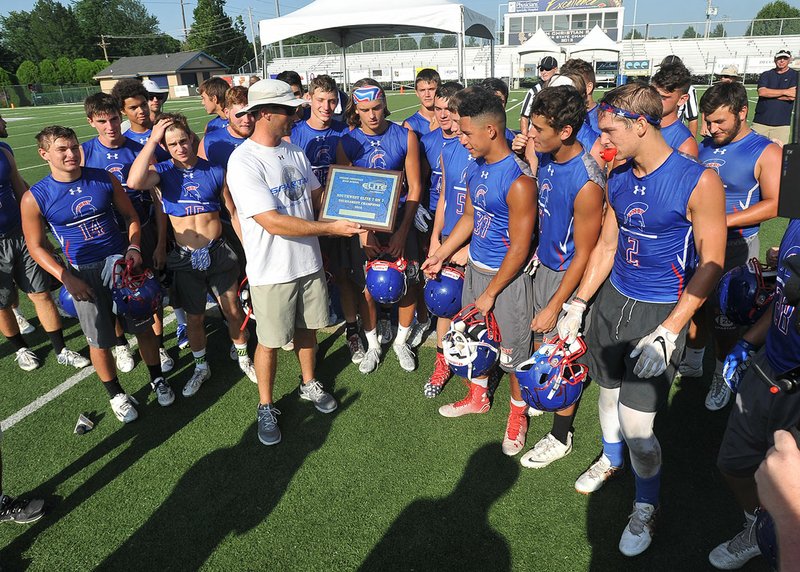 NWA Democrat-Gazette/MICHAEL WOODS
Bixby players receive their championship trophy Saturday after beating Aurora Christian in the championship game of Southwest Elite 7-on-7 tournament at Champions Stadium at Shiloh Christian in Springdale. 