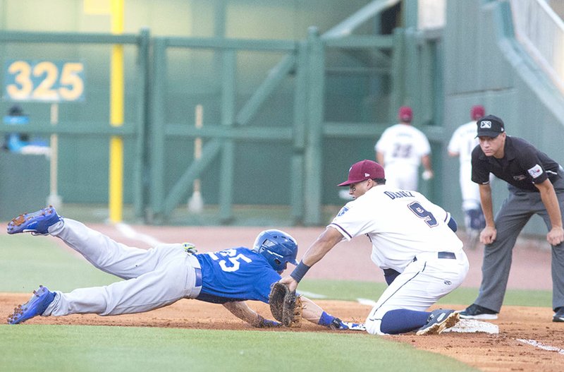 Special to NWA Democrat-Gazette/DAVID BEACH Tulsa's Blake Gailen (left) is tagged out by Naturals first baseman Samir Duenez on a pick-off play Thursday at Arvest Ballpark in Springdale.
