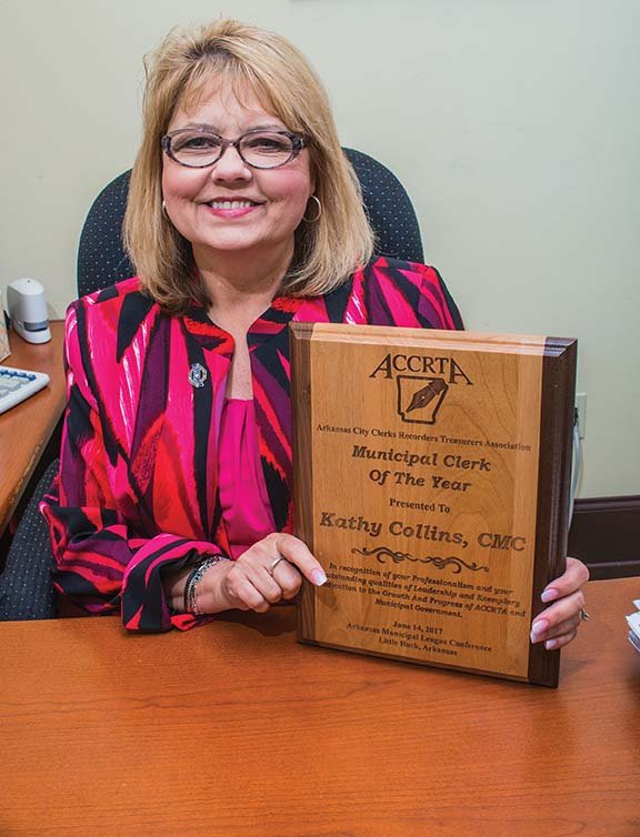 Kathy Collins holds her award for Arkansas Municipal Clerk of the Year. She was appointed in 2001 as Russellville city clerk-treasurer and has been re-elected since then. “If I can help someone, I’m going to,” Collins said. Mayor Randy Horton described her as a “conscientious hard worker.”
