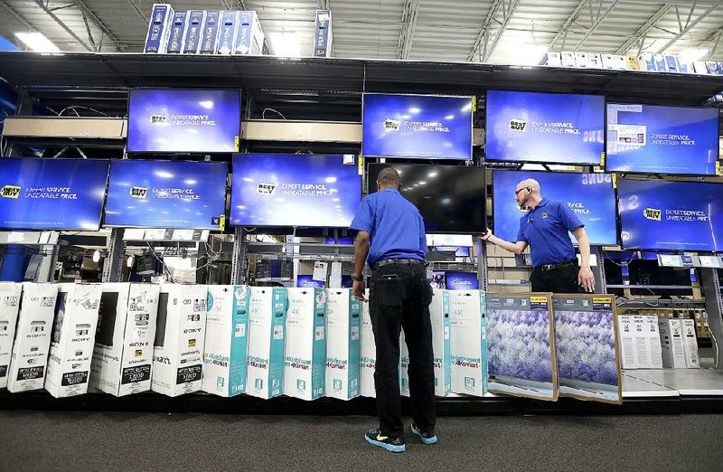 Best Buy employees work on a display at a store in Cary, N.C., in May. One economist called Friday’s report on slipping retail sales “a disappointment as far as the resilience of the consumer is concerned.” 