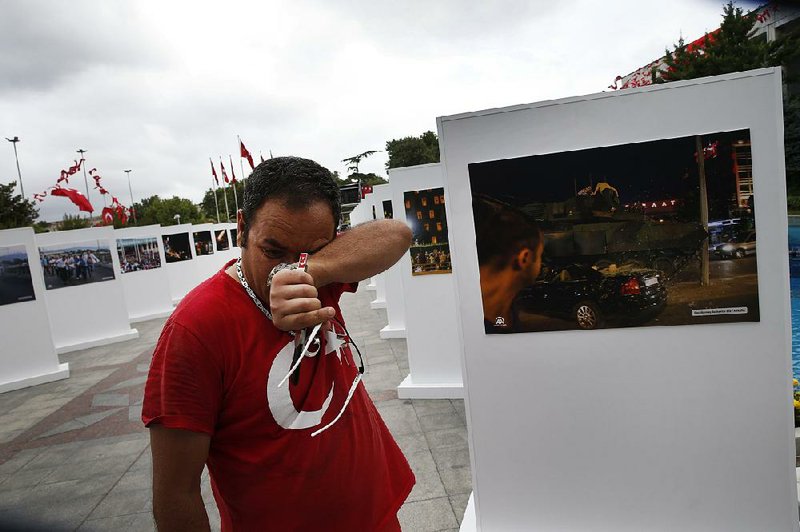Savas Altay weeps Friday in Istanbul at an exhibit of photographs from the military coup attempt last year. Altay said he was beaten by a soldier during the turmoil.